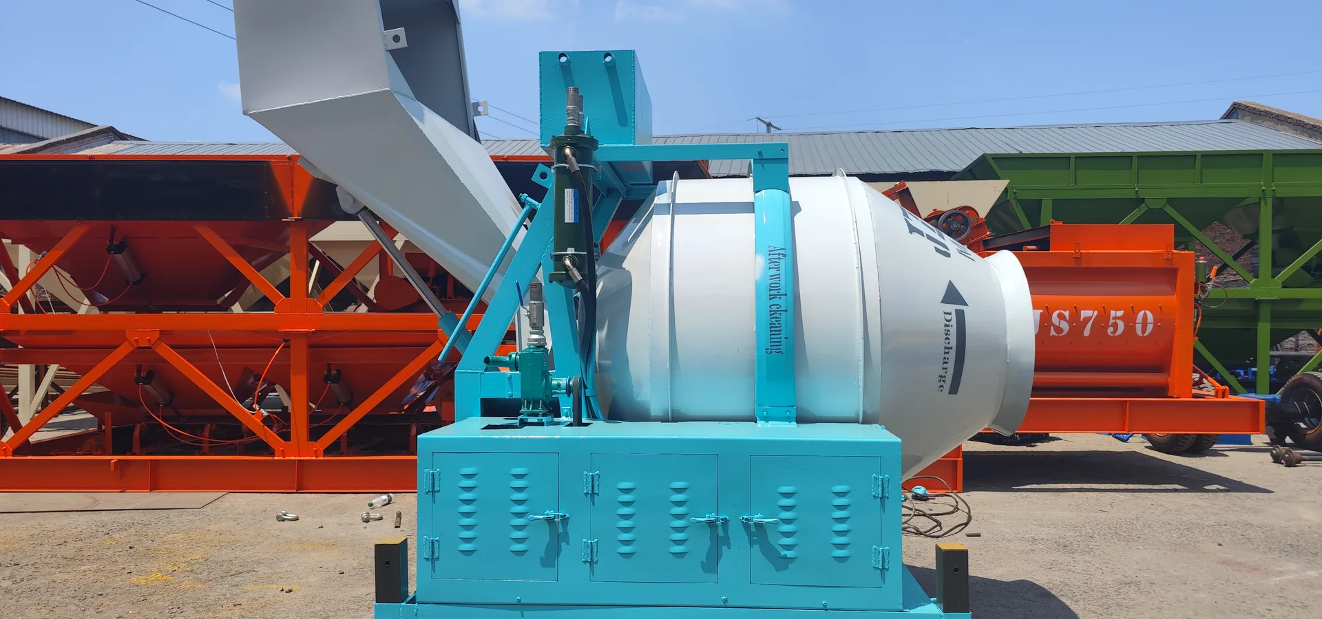 Concrete mixer with charging skip beside a batching plant